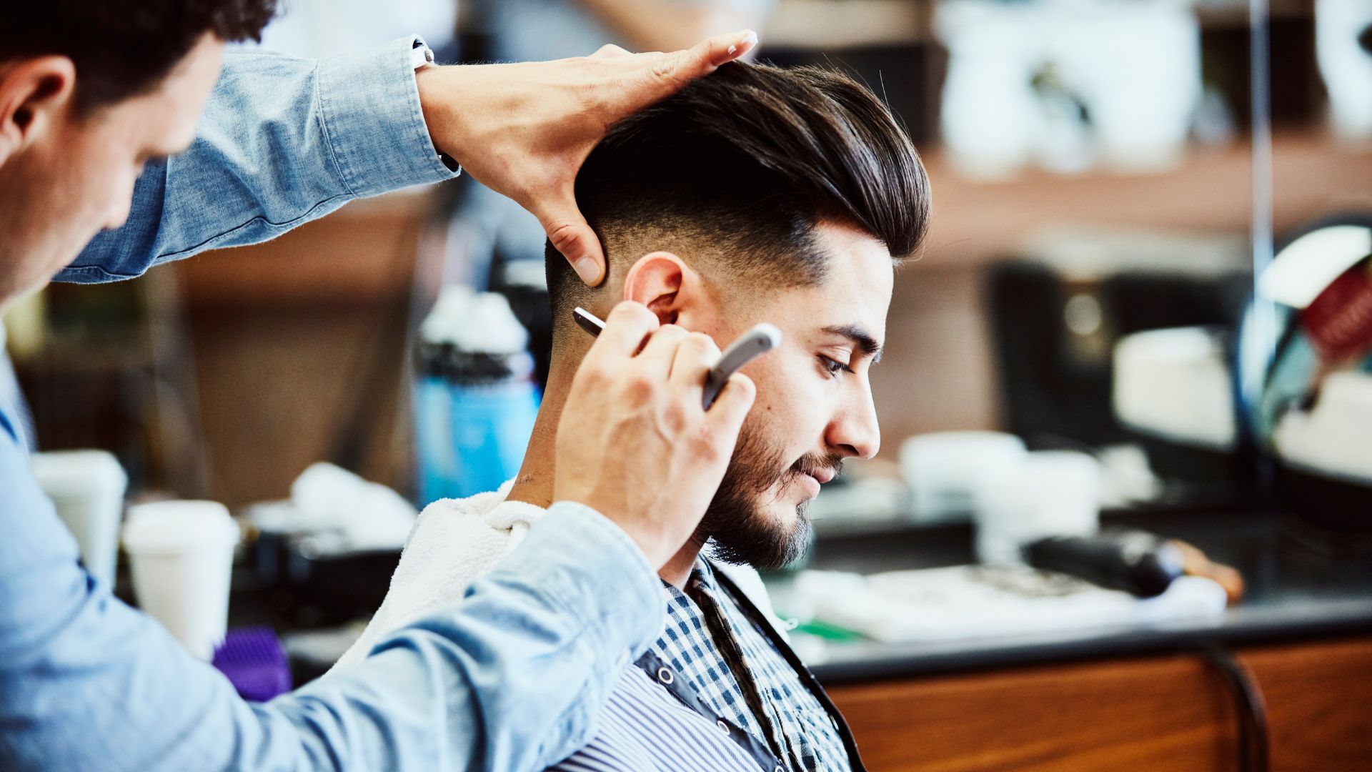 Barber carefully defining beard lines and shaping facial hair for a clean finish