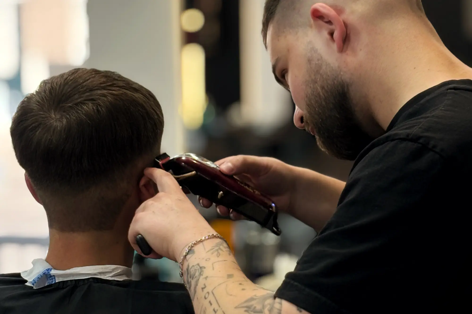 Barber performing a precision men's haircut with professional scissors and a comb